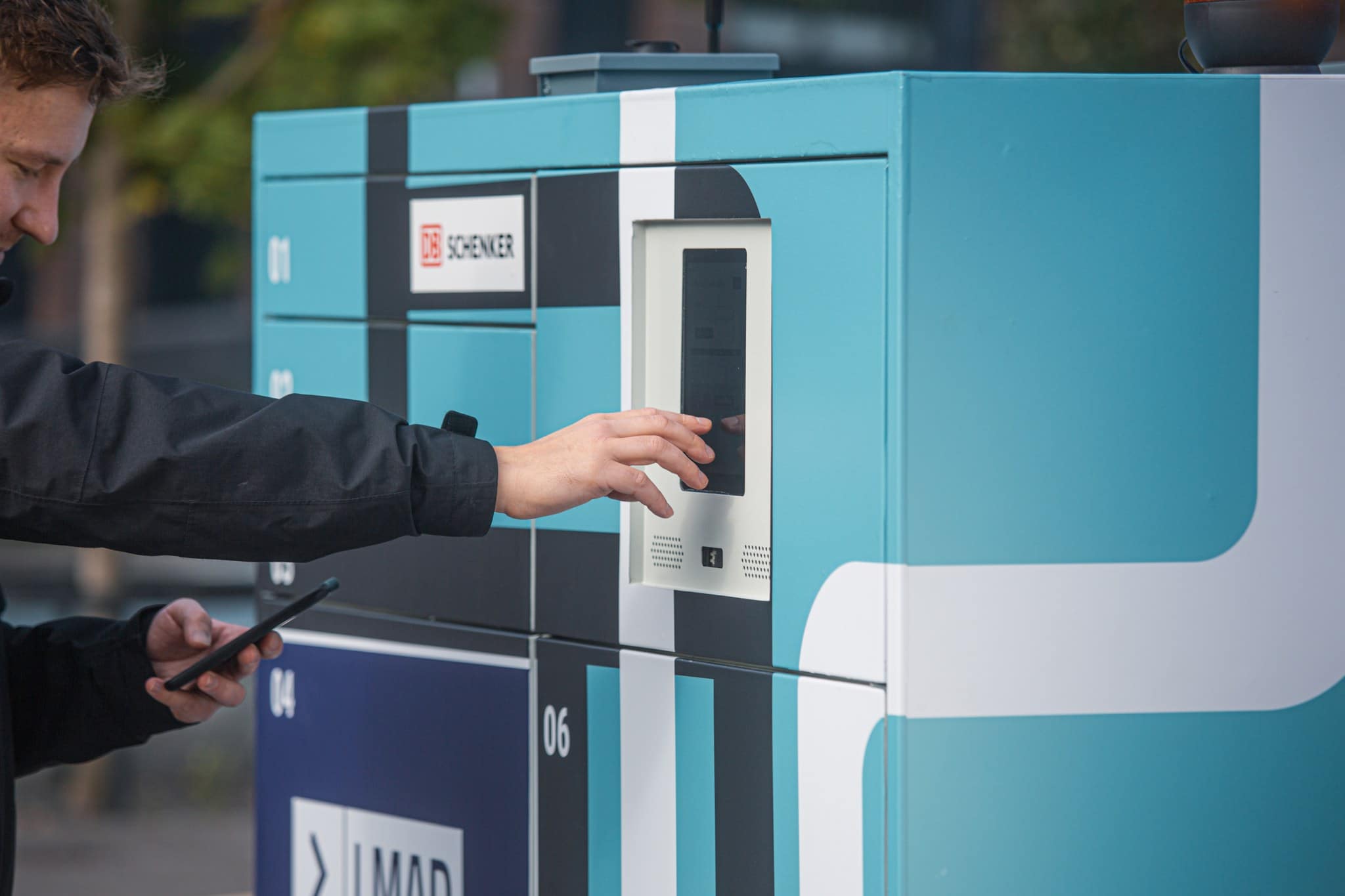 A close-up of a customer using the touch screen of the robot to receive a parcel