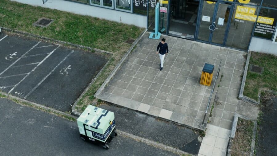 Aerial shot of the robot with a person approaching it